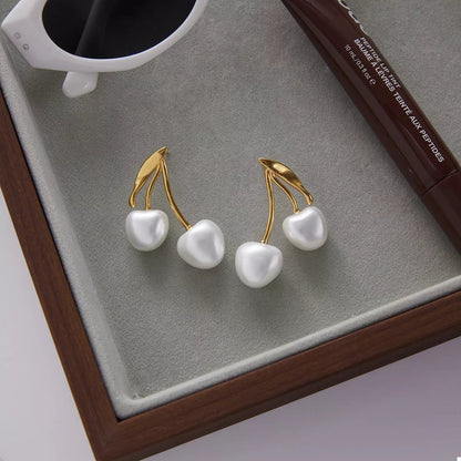 Front view of 18K Gold-Plated Pearl Cherry Earrings in Gold showing neckline and sleeve details