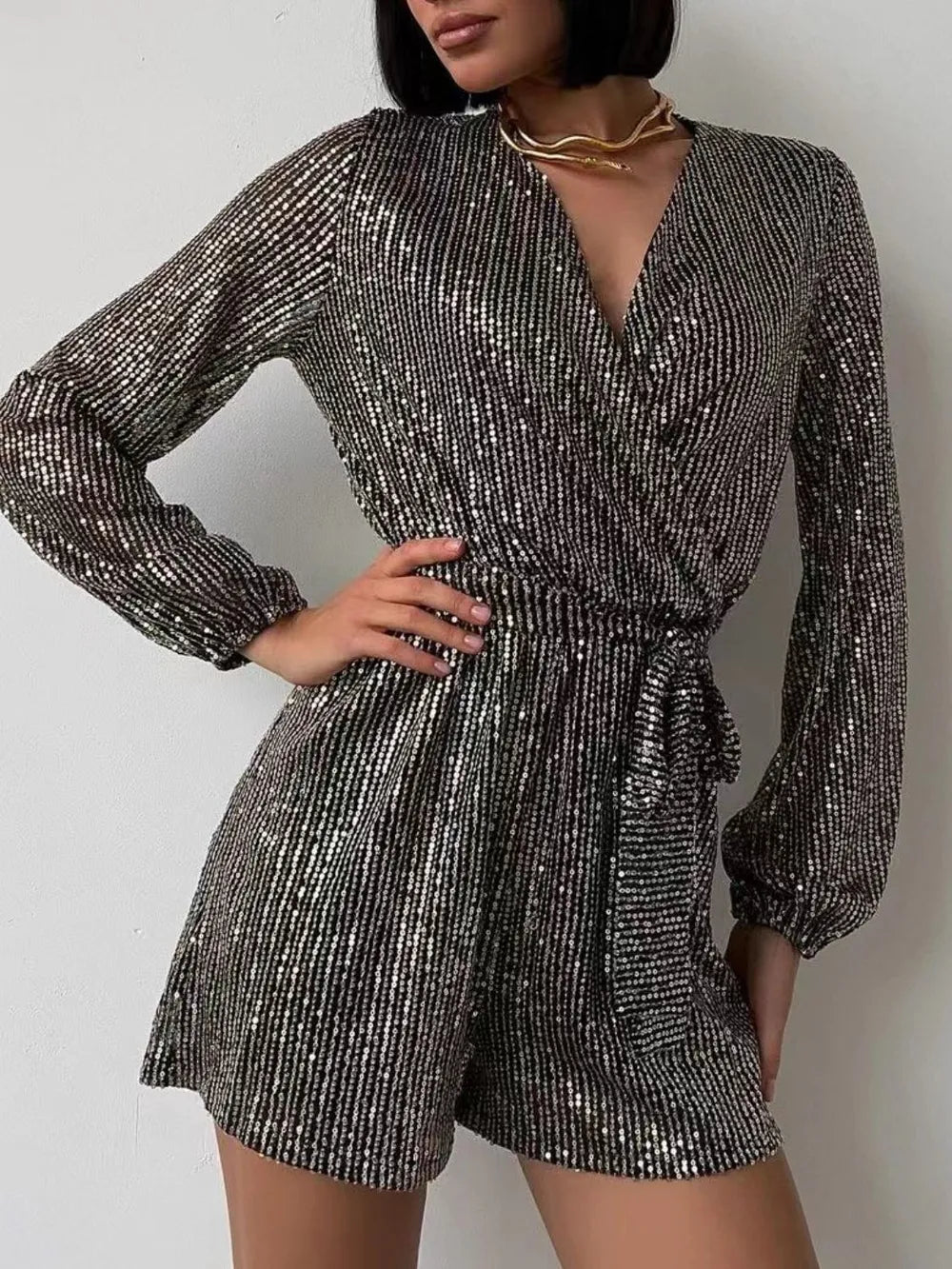 Front view of Full Size Sequin Surplice Tie Waist Long Sleeve Romper in Black/Silver showing neckline and sleeve details