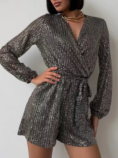 Front view of Full Size Sequin Surplice Tie Waist Long Sleeve Romper in Black/Silver showing neckline and sleeve details