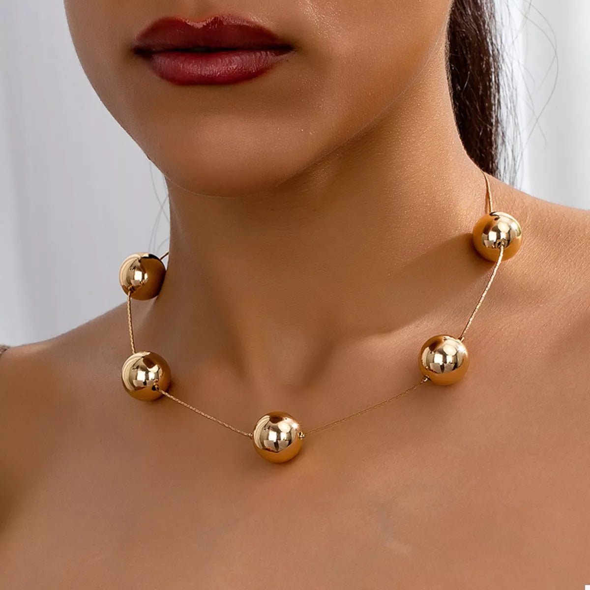 Front view of Golden Sphere Statement Necklace in Gold showing neckline and sleeve details