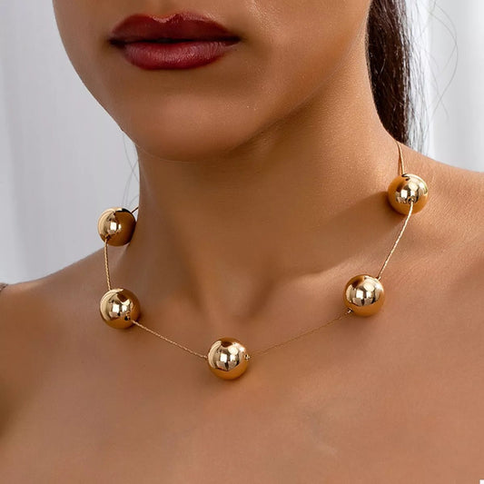 Front view of Golden Sphere Statement Necklace in Gold showing neckline and sleeve details