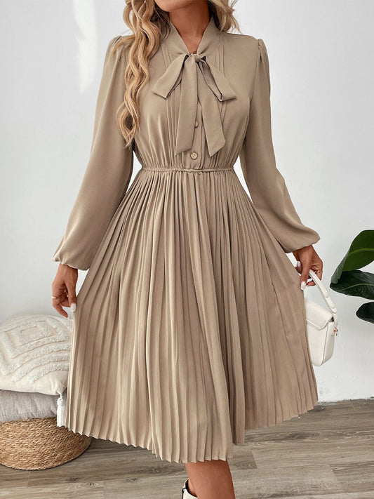 Front view of Perfee Pleated Tie Neck Long Sleeve Dress in Tan showing neckline and sleeve details